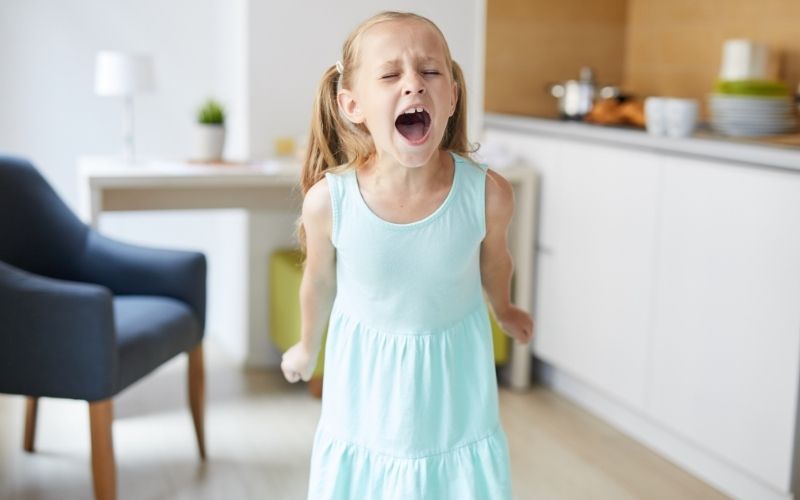 Toddler playing with blocks while a caregiver sits nearby